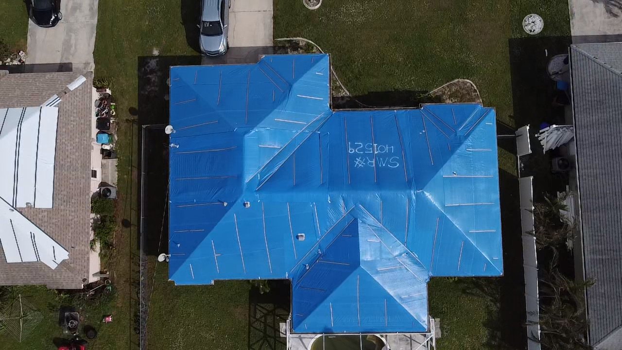 Roof fully tarped by Elite-Pro after storm damage, aerial view